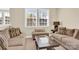Cozy living room featuring neutral sofas, a glass-topped coffee table, and a view through bright windows at 345 Somerled Way, Waxhaw, NC 28173