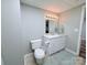 Well-lit bathroom featuring a white vanity, toilet, and a neutral-toned floor at 3704 25Th Street Ne Pl, Hickory, NC 28601