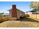 Exterior shot showcasing the home's backyard with a wooden fence, and brick chimney at 416 E Park Ave, Gastonia, NC 28054