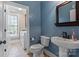 Charming powder room featuring blue patterned walls, pedestal sink, and convenient access to the laundry area at 4231 Brushy Knl, York, SC 29745