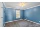 Bedroom featuring neutral carpet, blue walls, and ceiling light fixture at 4231 Brushy Knl, York, SC 29745
