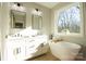 Modern bathroom showcasing a soaking tub with large window and double sink vanity at 472 Oak Rd # 114/115/116, Norwood, NC 28128