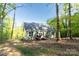 Rear exterior of home with two doors leading to a charming wooden deck nestled in a lush, wooded setting at 472 Oak Rd # 114/115/116, Norwood, NC 28128