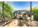 Rear exterior of home with two doors leading to a charming wooden deck nestled in a lush, wooded setting at 472 Oak Rd # 114/115/116, Norwood, NC 28128