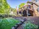 Multi-tiered backyard with deck, stone steps, and well-maintained lawn at 547 Ashby Dr, Davidson, NC 28036