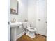 Powder room featuring a pedestal sink, toilet, and wood flooring at 547 Ashby Dr, Davidson, NC 28036