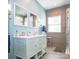 Bathroom with a dual sink vanity, framed mirrors, wood accent wall and glass enclosed shower at 547 Ashby Dr, Davidson, NC 28036