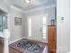 Bright foyer with front door, rug, wooden storage cabinet, and view to the staircase at 547 Ashby Dr, Davidson, NC 28036