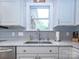 Close up of the sink area of the kitchen with stainless steel appliances and light colored backsplash at 547 Ashby Dr, Davidson, NC 28036