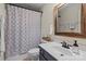 Cozy bathroom featuring floral shower curtain, single sink vanity, and framed mirror at 5854 Crimson Oak Ct, Harrisburg, NC 28075