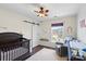 Cozy bedroom with a crib, neutral walls, and a view of the neighborhood at 5854 Crimson Oak Ct, Harrisburg, NC 28075