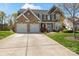 Charming brick two-story home with attached two car garage and a well-manicured lawn at 5854 Crimson Oak Ct, Harrisburg, NC 28075