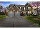 Charming two-story brick home with a manicured lawn and a two-car garage, perfect for Gathering living at 5854 Crimson Oak Ct, Harrisburg, NC 28075