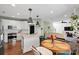 Open kitchen with stainless steel appliances, white cabinets, and breakfast table near window at 5854 Crimson Oak Ct, Harrisburg, NC 28075