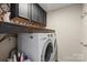 Well-organized laundry room with washer, dryer, and plenty of storage with shelves at 5854 Crimson Oak Ct, Harrisburg, NC 28075