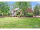 Well-kept home with a manicured lawn, mature trees, and shrubs enhancing its curb appeal at 6730 Gold Wagon Ln, Mint Hill, NC 28227