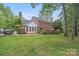 Sprawling backyard features a well-maintained lawn, mature trees, and a lovely deck at 6730 Gold Wagon Ln, Mint Hill, NC 28227