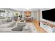 Open-concept living and dining area with hardwood floors, large windows, and a brick fireplace at 6730 Gold Wagon Ln, Mint Hill, NC 28227