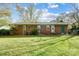 A brick home featuring a well-maintained backyard, with a grassy yard and an enclosed area at 7000 David Ave, Charlotte, NC 28214