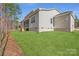 Large backyard with a green lawn, trees, and a screened-in porch, perfect for outdoor activities at 7005 New Town Rd, Waxhaw, NC 28173