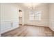 Elegant dining room with wainscoting, a chandelier, and views of the landscaped yard at 7005 New Town Rd, Waxhaw, NC 28173