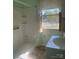 Bathroom with a combined shower and tub unit next to window with sink and toilet at 701 Dakota St, Kannapolis, NC 28083