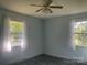 Bedroom featuring blue walls, two large windows, and a ceiling fan with overhead lighting at 701 Dakota St, Kannapolis, NC 28083