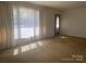 Bright living room featuring large windows and neutral carpeting at 701 Dakota St, Kannapolis, NC 28083
