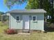 A small light green shed with a gray roof, a white door, a pair of small windows and concrete steps at 701 Dakota St, Kannapolis, NC 28083