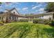 Large grassy backyard with a partial view of the house and a covered parking area at 7900 Gilead Rd, Huntersville, NC 28078