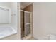 Bathroom featuring a tiled standing shower, soaking tub and neutral colors at 7900 Gilead Rd, Huntersville, NC 28078