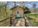 Backyard outbuilding is surrounded by trees with a wooden walkway leading to the entrance at 7900 Gilead Rd, Huntersville, NC 28078