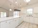Bright kitchen area with white cabinets, spacious countertop, and a view into the living space at 9287 Meadow Vista Rd, Charlotte, NC 28213