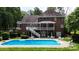 Back of red brick home with second story covered porch overlooking in-ground pool at 101 Saddletree Rd, Lincolnton, NC 28092
