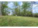 Expansive backyard features a lush lawn, mature trees, and distant view of the house at 1027 Williamston Dr, Marshville, NC 28103