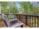 View of wood deck with above ground pool surrounded by lush greenery and Adirondack chairs at 1027 Williamston Dr, Marshville, NC 28103
