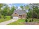 Charming brick home with attached garage, long driveway, and well manicured lawn at 1027 Williamston Dr, Marshville, NC 28103