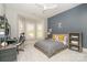 A cozy bedroom featuring a bay window, ceiling fan, gray and blue color scheme, and comfortable furniture at 1029 Seminole Dr, Waxhaw, NC 28173