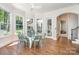 Bright breakfast nook featuring a glass table, green chairs, and expansive windows overlooking a lush yard at 1029 Seminole Dr, Waxhaw, NC 28173