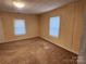 Bedroom featuring two windows letting in natural light, beige paint and carpet at 109 Starnes St, Chester, SC 29706