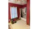 Bathroom with a toilet, window, and shower/tub with curtain and red painted walls at 1336 Mt Sinai Church Rd, Shelby, NC 28152