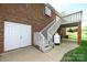 A brick home with double doors, gas tank, and deck access via stairs, showcasing its functional outdoor features at 1353 33Rd Avenue Ne Dr, Hickory, NC 28601