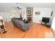 Bright living room features hardwood floors, ceiling fan, and stone fireplace at 1353 33Rd Avenue Ne Dr, Hickory, NC 28601
