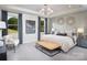 A spacious main bedroom featuring an elegant chandelier, stylish decor, and ample natural light at 1468 Honey Trl, Monroe, NC 28112