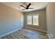Cozy bedroom with ceiling fan, light walls, and large window overlooking a serene outdoor view at 15170 Cove Point Ln, Norwood, NC 28128