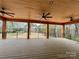 Large covered deck with ceiling fans offers serene backyard and wooded views at 15170 Cove Point Ln, Norwood, NC 28128