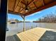 Waterfront view showcasing a modern boathouse and dock with a ceiling fan for pleasant lake enjoyment at 15170 Cove Point Ln, Norwood, NC 28128