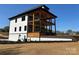 View of a modern three-story home featuring a large deck and multiple balconies, perfect for outdoor living and entertaining at 15170 Cove Point Ln, Norwood, NC 28128