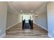 Wide hallway with wood flooring, windows at the end, and decorative trim, offers an open, airy feel at 15170 Cove Point Ln, Norwood, NC 28128