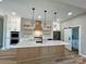 Modern kitchen featuring a central island, stainless steel appliances, custom cabinets, and stylish pendant lighting at 15170 Cove Point Ln, Norwood, NC 28128